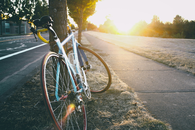 Nærbillede af en cykel på en vej i den gyldne aftensol